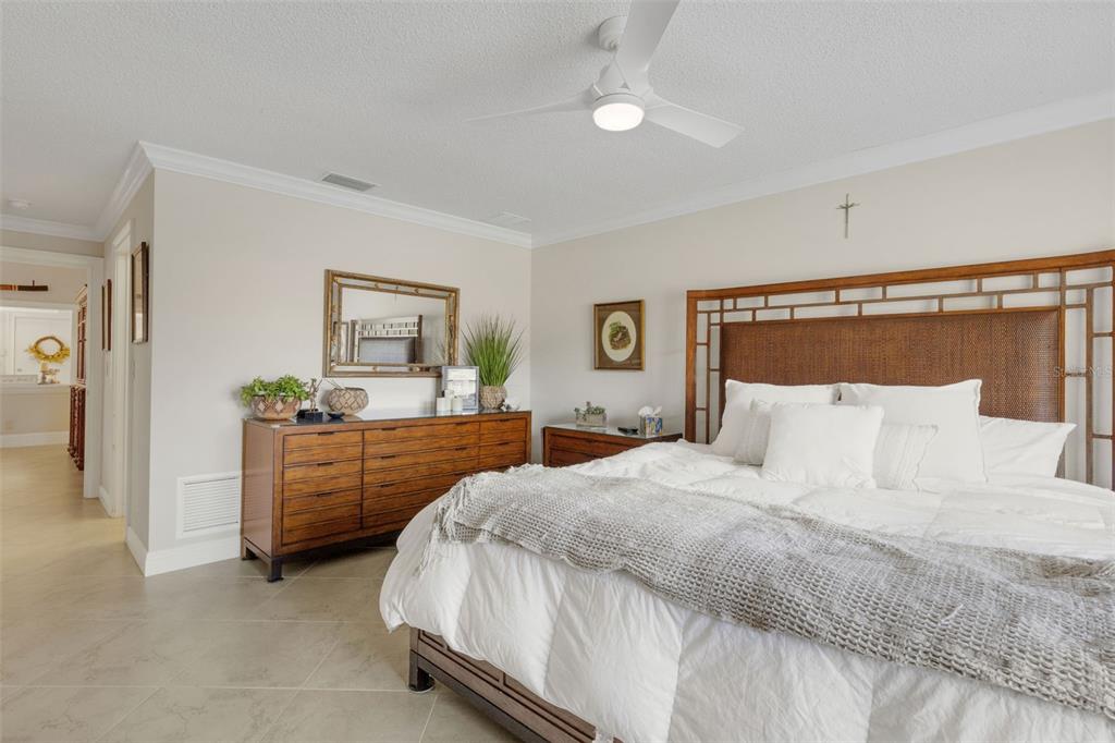 A bedroom features a wooden headboard, a dresser with a mirror, and tile flooring — 3902 WILSHIRE DRIVE UNIT 98, SARASOTA, FL