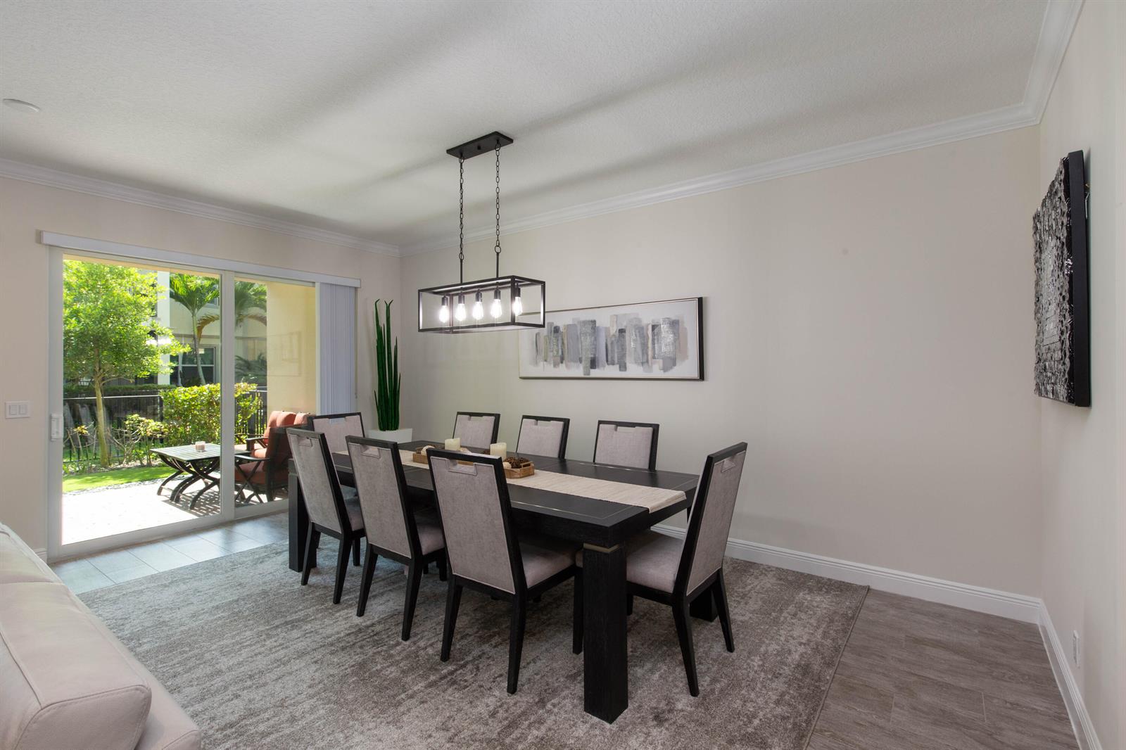 A dining room features a dark wood table, six upholstered chairs, and a sliding glass door — 168 Crape Myrtle Lane, Wellington FL 33414, WELLINGTON, FL