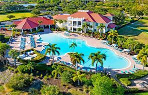 An aerial view of a large clubhouse with a red roof and a swimming pool — 3957 Cranesbill Court, FL 33920, FL