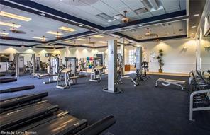 A spacious fitness center features rows of treadmills, weight machines, and a dark carpeted floor — 3957 Cranesbill Court, FL 33920, FL