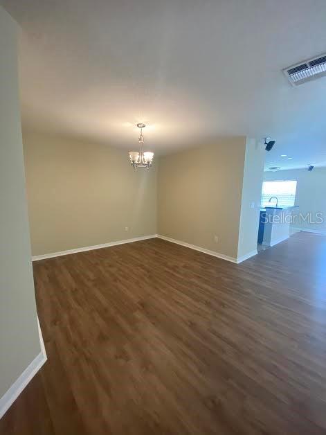 An open-concept dining area features a chandelier, light-colored walls, and wood-look flooring — 3399 CARUSO PLACE, OVIEDO, FL