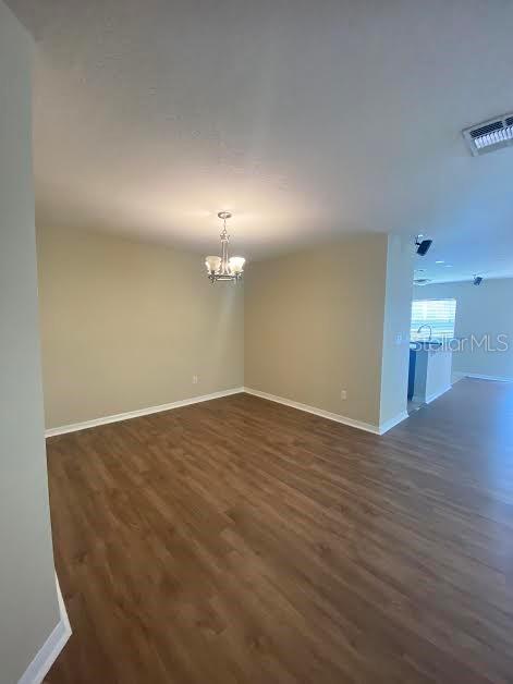 An open-concept dining area features light-colored walls, wood-look flooring, and a central chandelier — 3399 CARUSO PLACE, OVIEDO, FL