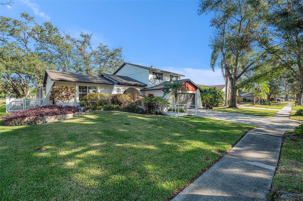 A two-story house with a white exterior, a garage, and a front lawn with landscaping — 4611 LANDSCAPE DRIVE, TAMPA, FL