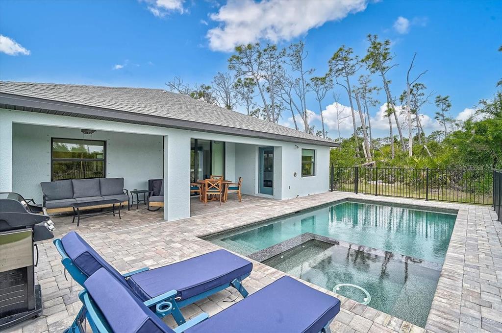 A patio with a pool and spa features lounge chairs, outdoor seating, and a grill — 112 HERCULES DRIVE, ROTONDA WEST, FL