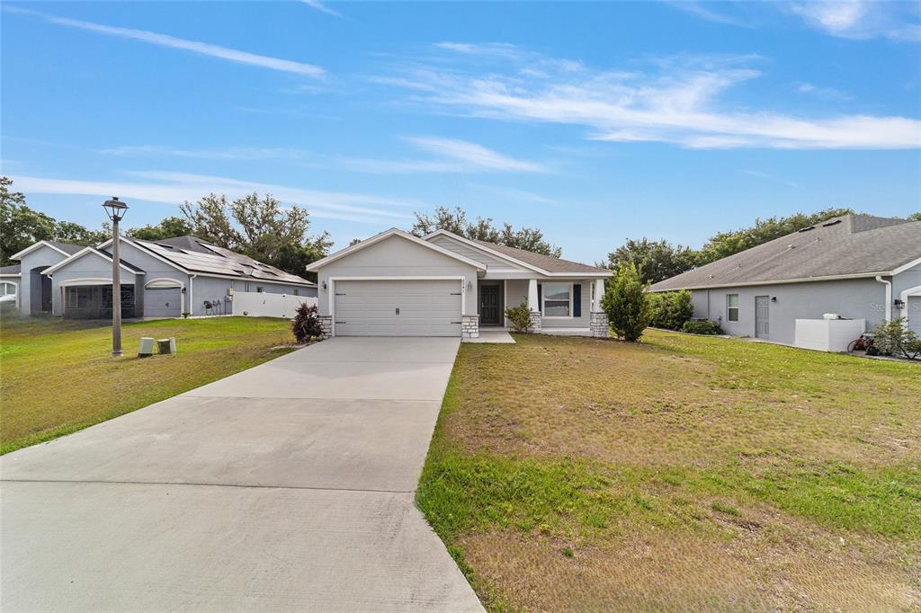 A single-story house with a gray exterior, a two-car garage, and a concrete driveway — 8941 SE 51ST, OCALA, FL