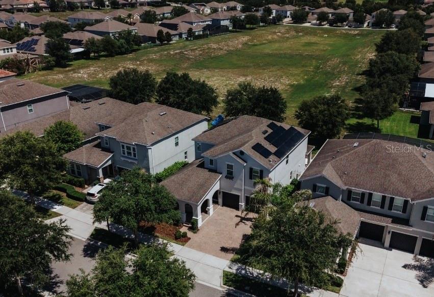 An aerial view shows a suburban house with solar panels on the roof and a driveway — 5024 PALMETTO PARK DRIVE, WINTER GARDEN, FL