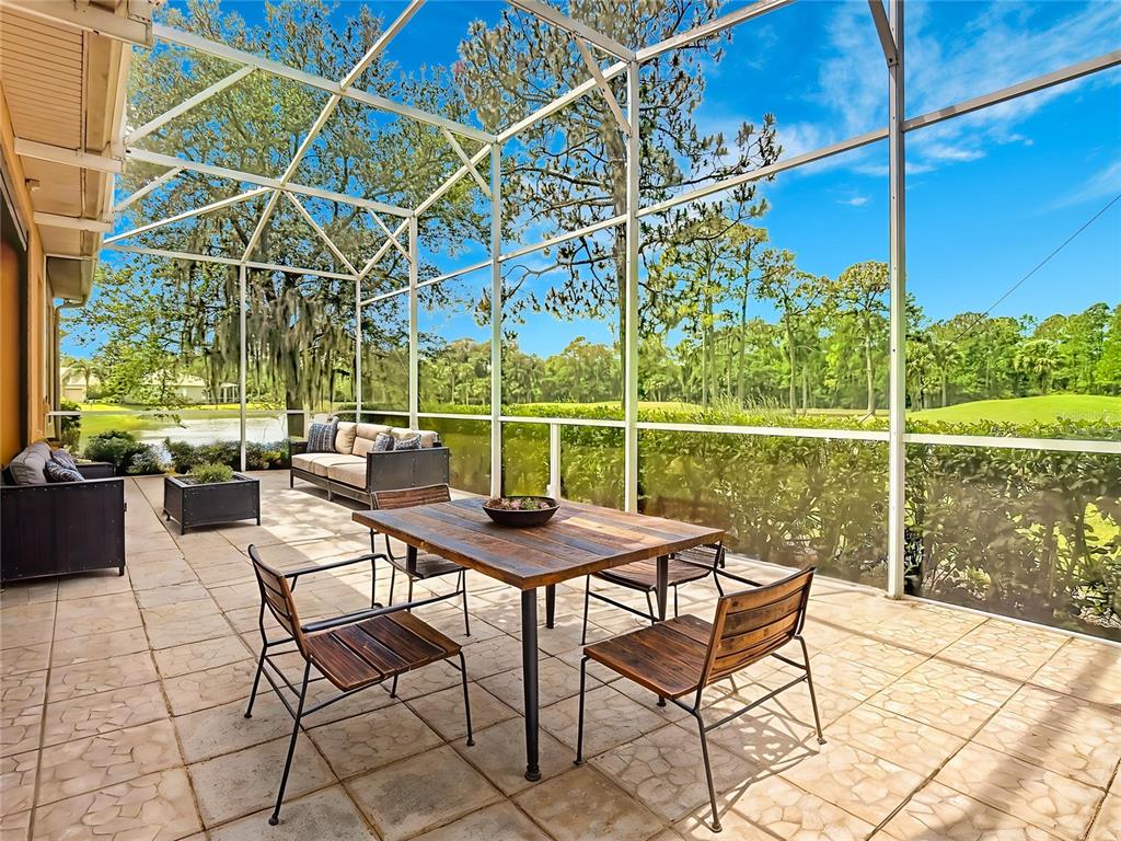 A screened-in patio features a dining set, lounge furniture, and views of a golf course — 294 ADDISON DRIVE, POINCIANA, FL