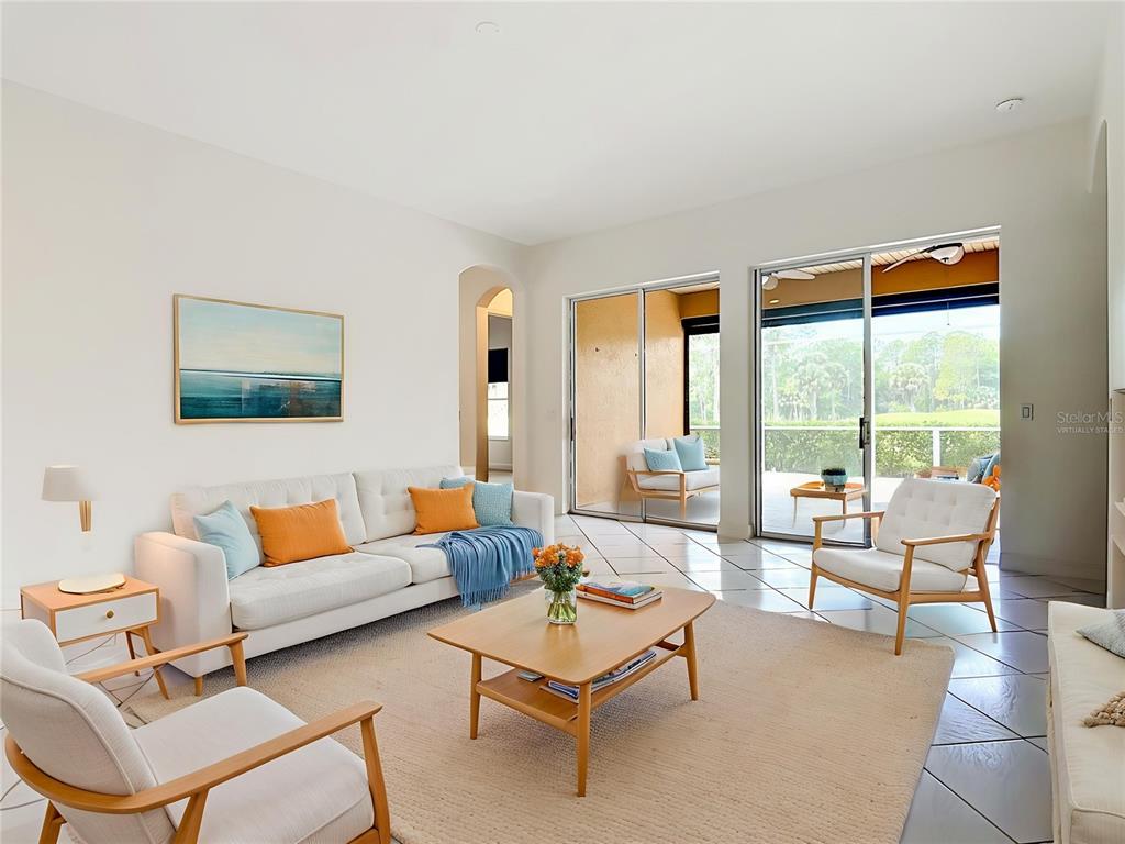 A living room features a white sofa, two armchairs, a coffee table, and sliding glass doors — 294 ADDISON DRIVE, POINCIANA, FL