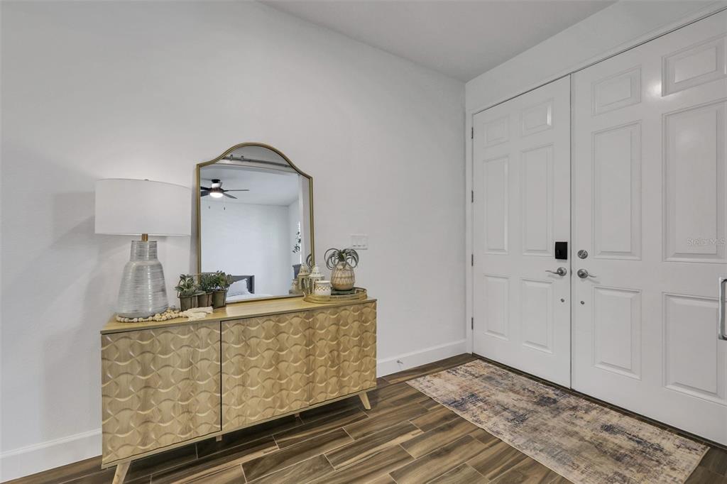 An entryway features a wooden cabinet, a table lamp, and double white front doors — 6226 W FALLSGROVE LANE, PORT ORANGE, FL
