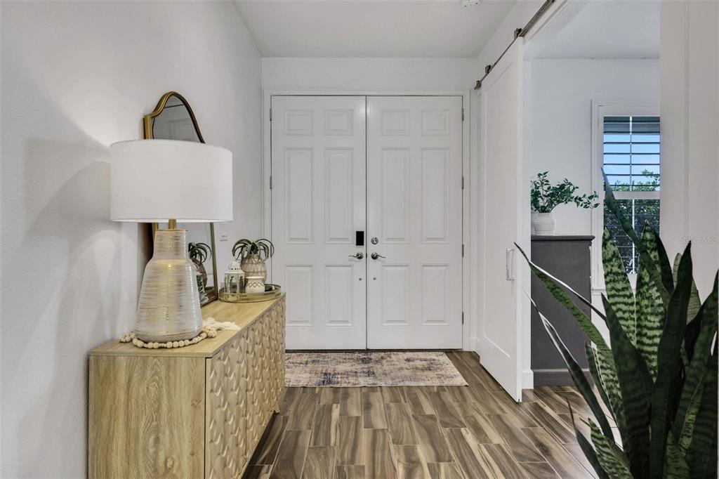 A modern kitchen features white cabinetry, a large quartz island, and stainless steel appliances — 6226 W FALLSGROVE LANE, PORT ORANGE, FL