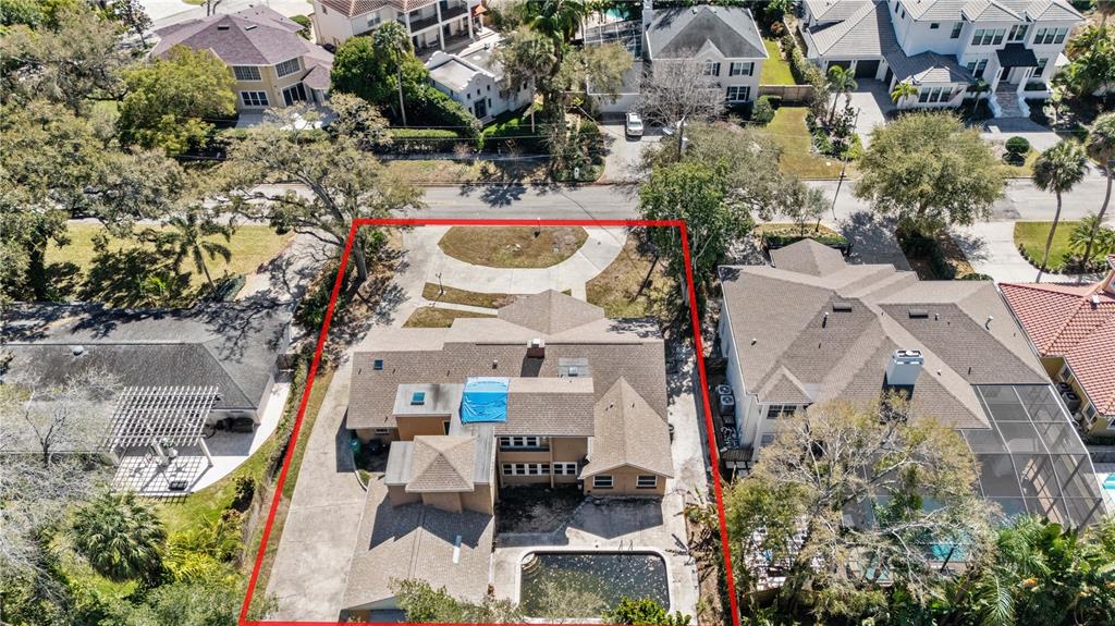 An aerial view shows a house with a blue tarp on the roof and a pool — 4205 W AZEELE STREET, TAMPA, FL