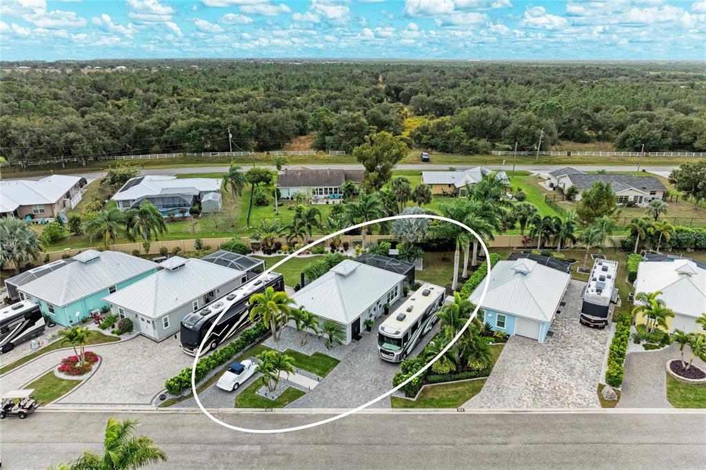 An aerial view shows a house with a large paved driveway and two parked motorhomes — 8688 SW SAND CRANE CIRCLE LOT 44, ARCADIA, FL