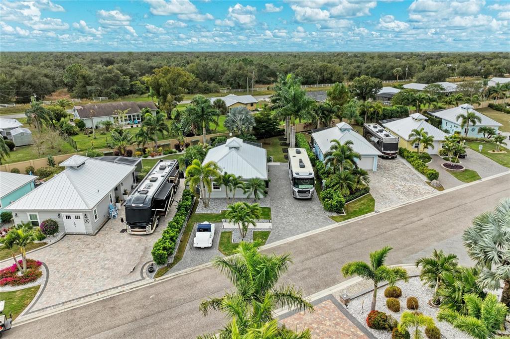 An aerial view shows several houses with metal roofs and RVs parked on paved driveways — 8688 SW SAND CRANE CIRCLE LOT 44, ARCADIA, FL