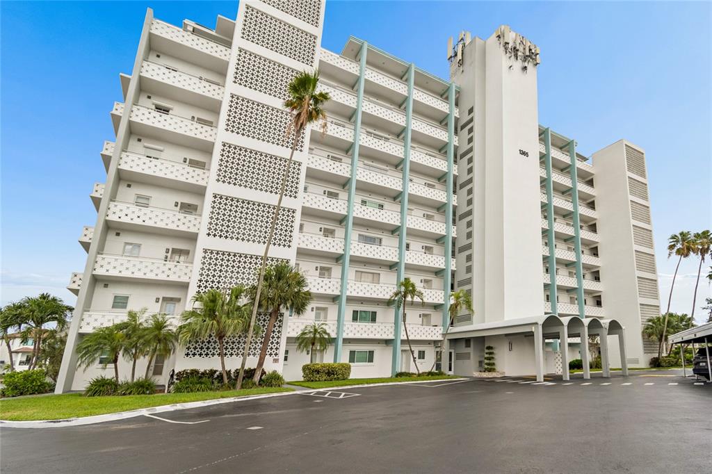 A multi-story white apartment building features balconies with decorative latticework and a covered entrance — 1365 N SNELL ISLE BOULEVARD NE UNIT 2E, ST PETERSBURG, FL