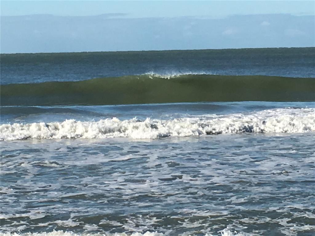 A view of ocean waves rolling toward the shore under a clear blue sky — 7740 SANDERLING ROAD, SARASOTA, FL
