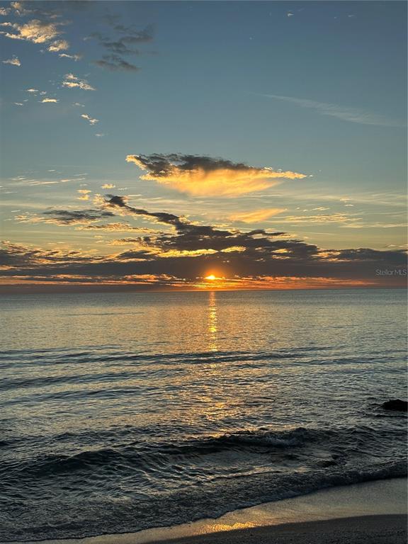 A sunset view over the ocean with waves washing onto a sandy beach — 7740 SANDERLING ROAD, SARASOTA, FL