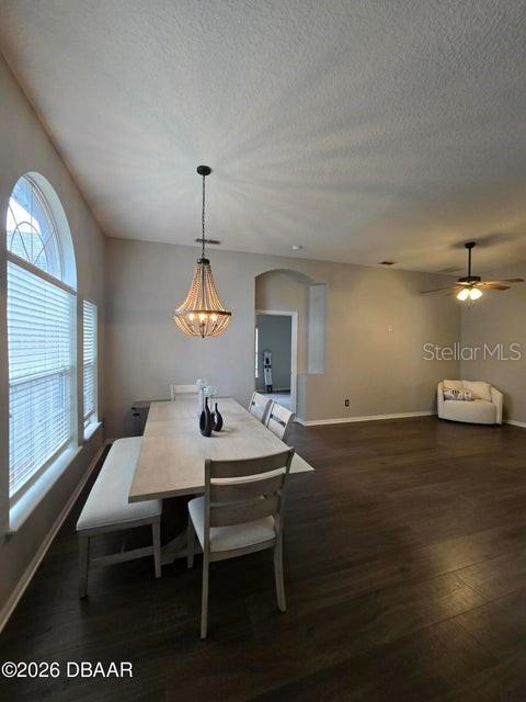 A dining area features a wooden table, a bench, chairs, and a beaded chandelier — 1409 SUTTON ISLAND DRIVE, DELAND, FL