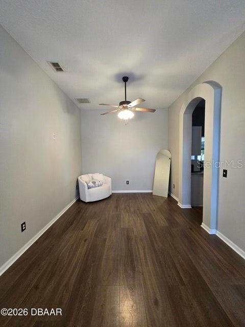 A room with wood-look flooring, a ceiling fan, and a white chair in the corner — 1409 SUTTON ISLAND DRIVE, DELAND, FL