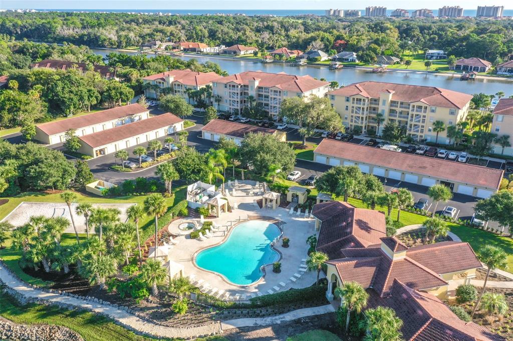An aerial view of a residential complex featuring a swimming pool and multi-story buildings — 1300 CANOPY WALK LANE UNIT 1314, PALM COAST, FL