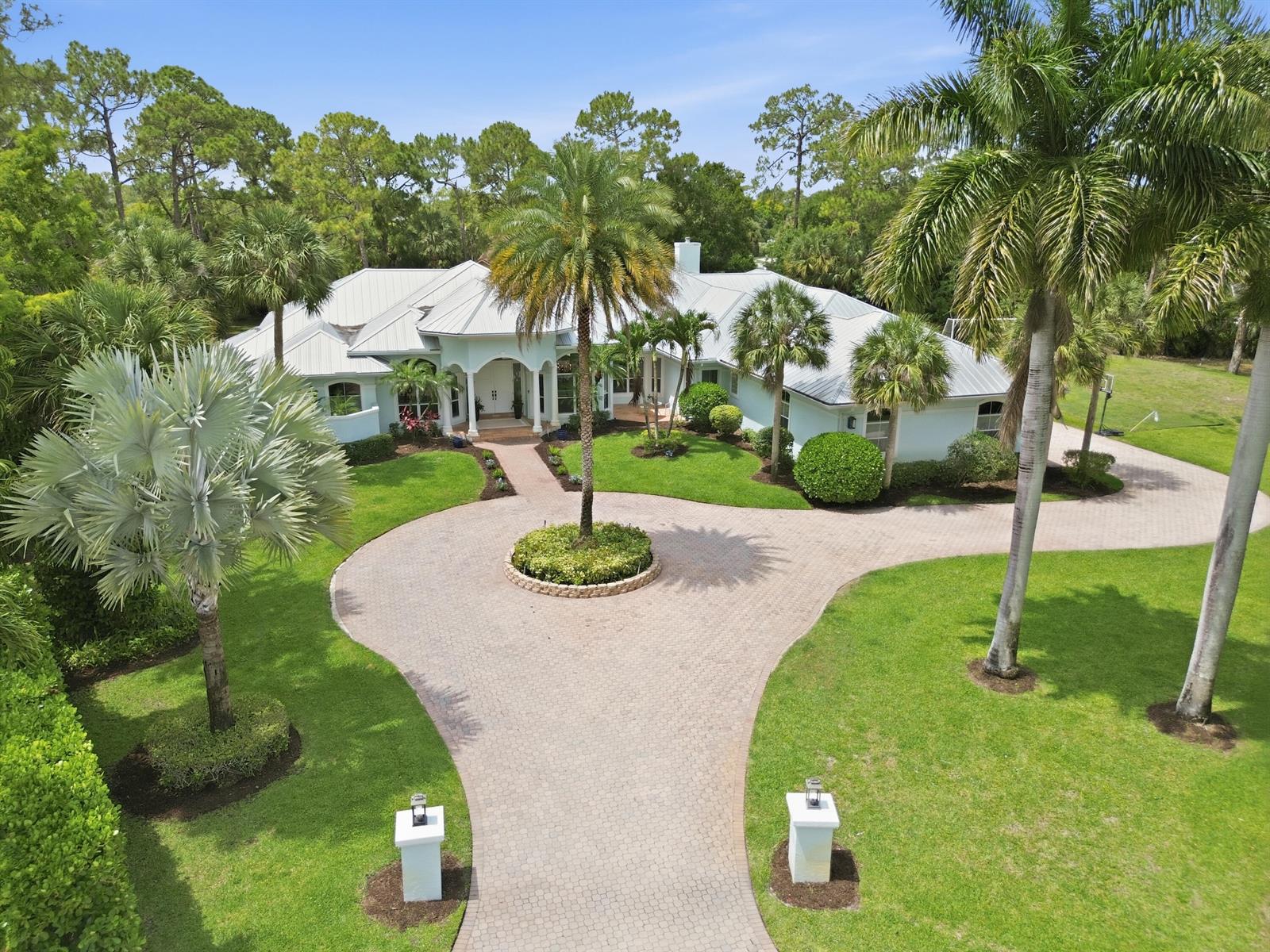 An aerial view of a light-colored house with a metal roof and circular driveway — 14737 Morgan Close, Wellington FL 33414, WELLINGTON, FL