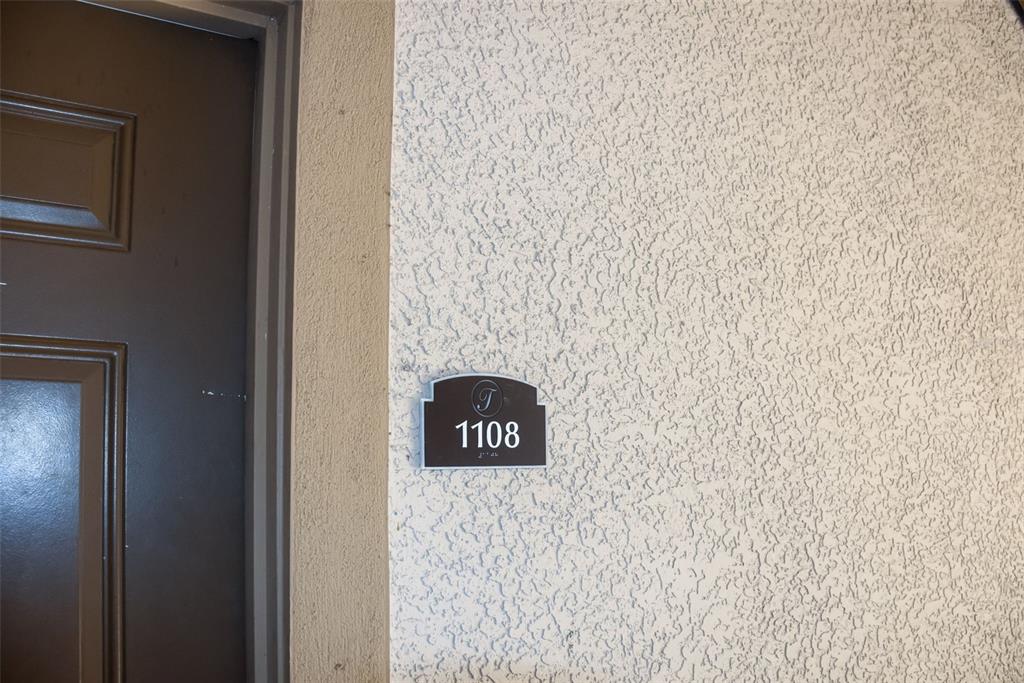 A dark brown door sits next to a textured wall with a unit number sign — 1375 TUSCANA LANE UNIT 1108, DAVENPORT, FL
