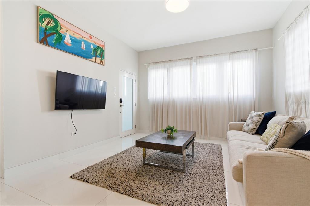 A living room features a wall-mounted television, a coffee table on a rug, and a sofa — 56 CALLE F KRUG CONDADO UNIT 2, SAN JUAN, PR