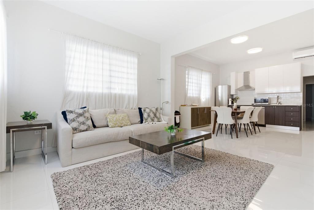 A living room with a sofa and coffee table opens into a modern kitchen area — 56 CALLE F KRUG CONDADO UNIT 2, SAN JUAN, PR