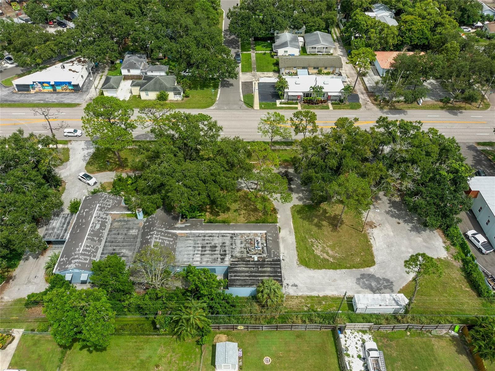 An aerial view shows a commercial building with a flat roof and a large parking lot — 4100 N 16th Street, FL 33703, FL