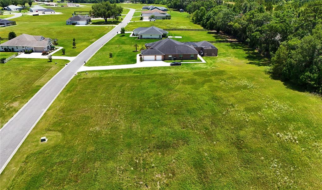 An aerial view shows a large residential lot with a house and a paved road — XX NW 79TH LOOP, OCALA, FL