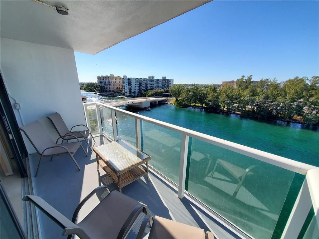A balcony with outdoor furniture overlooks a bridge, a waterway, and distant buildings — 1401 N Riverside Drive # 807, Pompano Beach FL 33062, POMPANO BEACH, FL