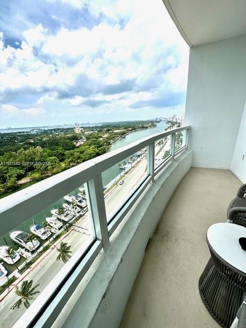 A high-rise balcony overlooks a waterway, a road, and a lush green landscape — 4401 Collins Ave # 1817, Miami Beach FL 33140, MIAMI BEACH, FL