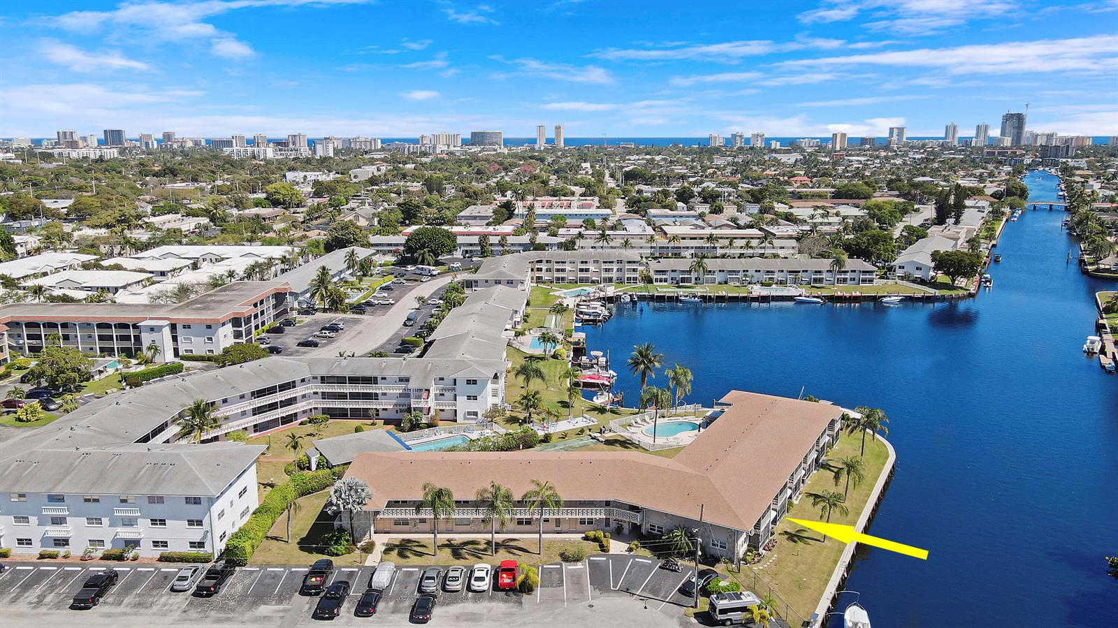 An aerial view shows a multi-story apartment complex situated along a canal with parking — 298 SE 6th Avenue # 6, Pompano Beach FL 33060, POMPANO BEACH, FL