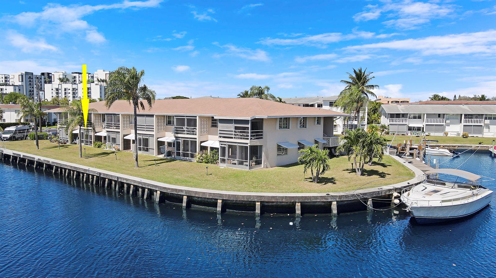 An exterior view of a multi-story waterfront apartment building with a boat docked nearby — 298 SE 6th Avenue # 6, Pompano Beach FL 33060, POMPANO BEACH, FL