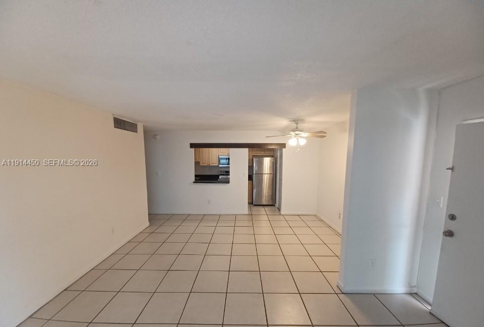 An open-concept living area features light-colored floor tiles, white walls, and a pass-through kitchen — 4330 NW 79th Ave # 2D, Doral FL 33166, DORAL, FL