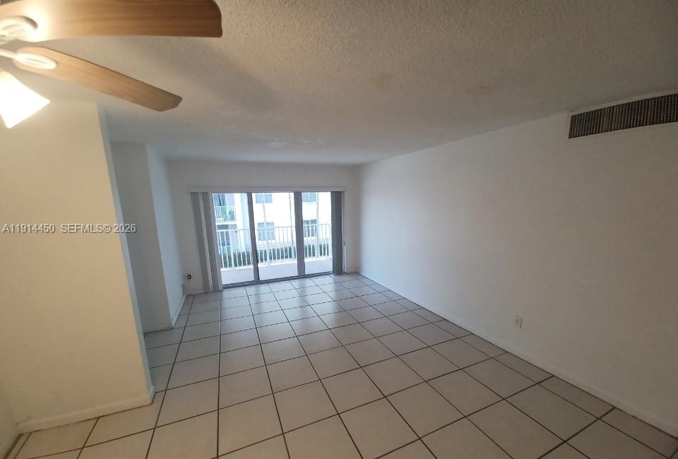 An empty room with white walls, tiled floors, and a sliding glass door to a balcony — 4330 NW 79th Ave # 2D, Doral FL 33166, DORAL, FL