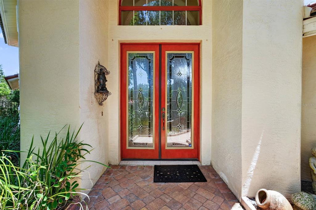 A front entryway features red double doors with glass inserts and a brick floor — 10 MONTERREY DRIVE, PALM COAST, FL