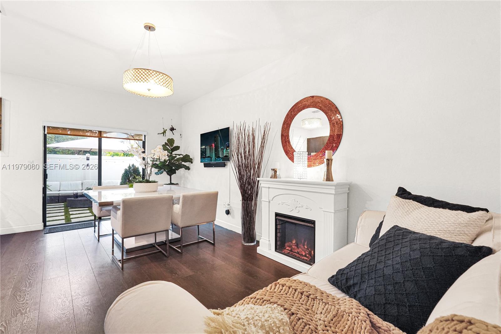 A living and dining area features a fireplace, a television, and a sliding glass door — 3321 W 105th Pl, Hialeah FL 33018, HIALEAH, FL