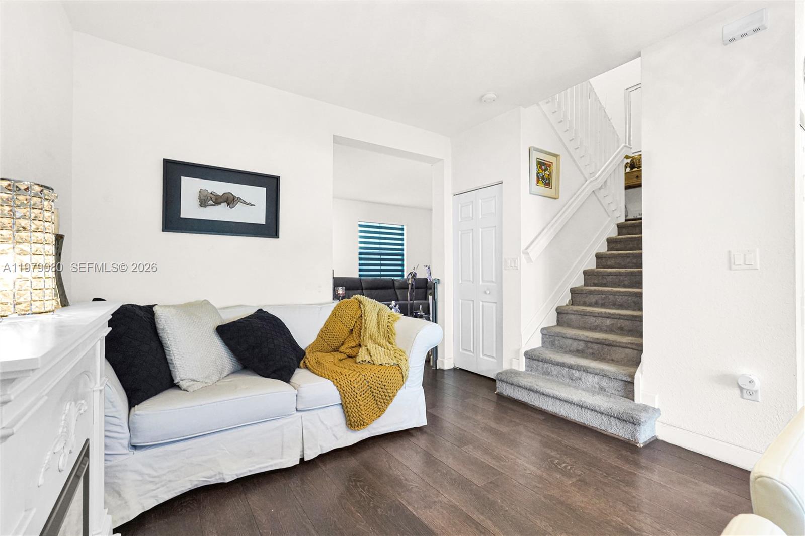 A living room features a white sofa, dark wood flooring, and a carpeted staircase — 3321 W 105th Pl, Hialeah FL 33018, HIALEAH, FL