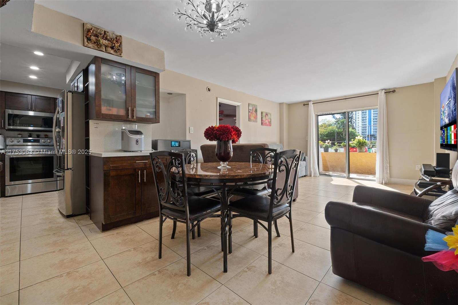 A dining area with a round table and dark cabinets opens to a living room — 4801 NW 7th St # 16, Miami FL 33126, MIAMI, FL