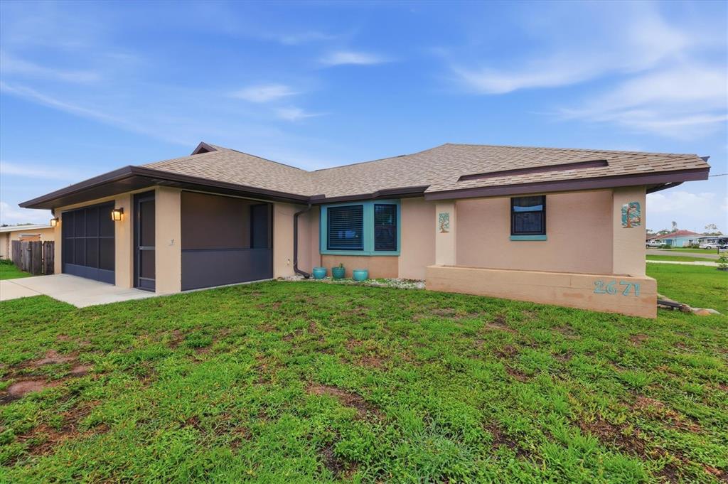 A single-story house with a tan stucco exterior, a brown roof, and a screened-in porch — 2671 YUCCA ROAD, VENICE, FL