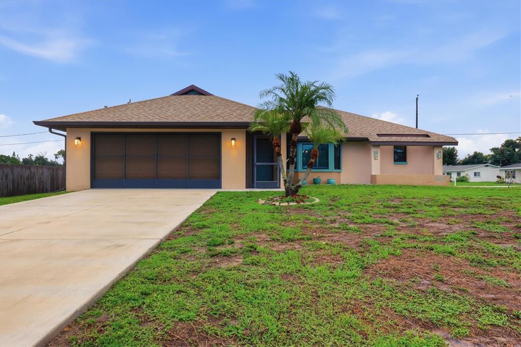 A single-story house with a tan exterior, a brown roof, and a concrete driveway — 2671 YUCCA ROAD, VENICE, FL