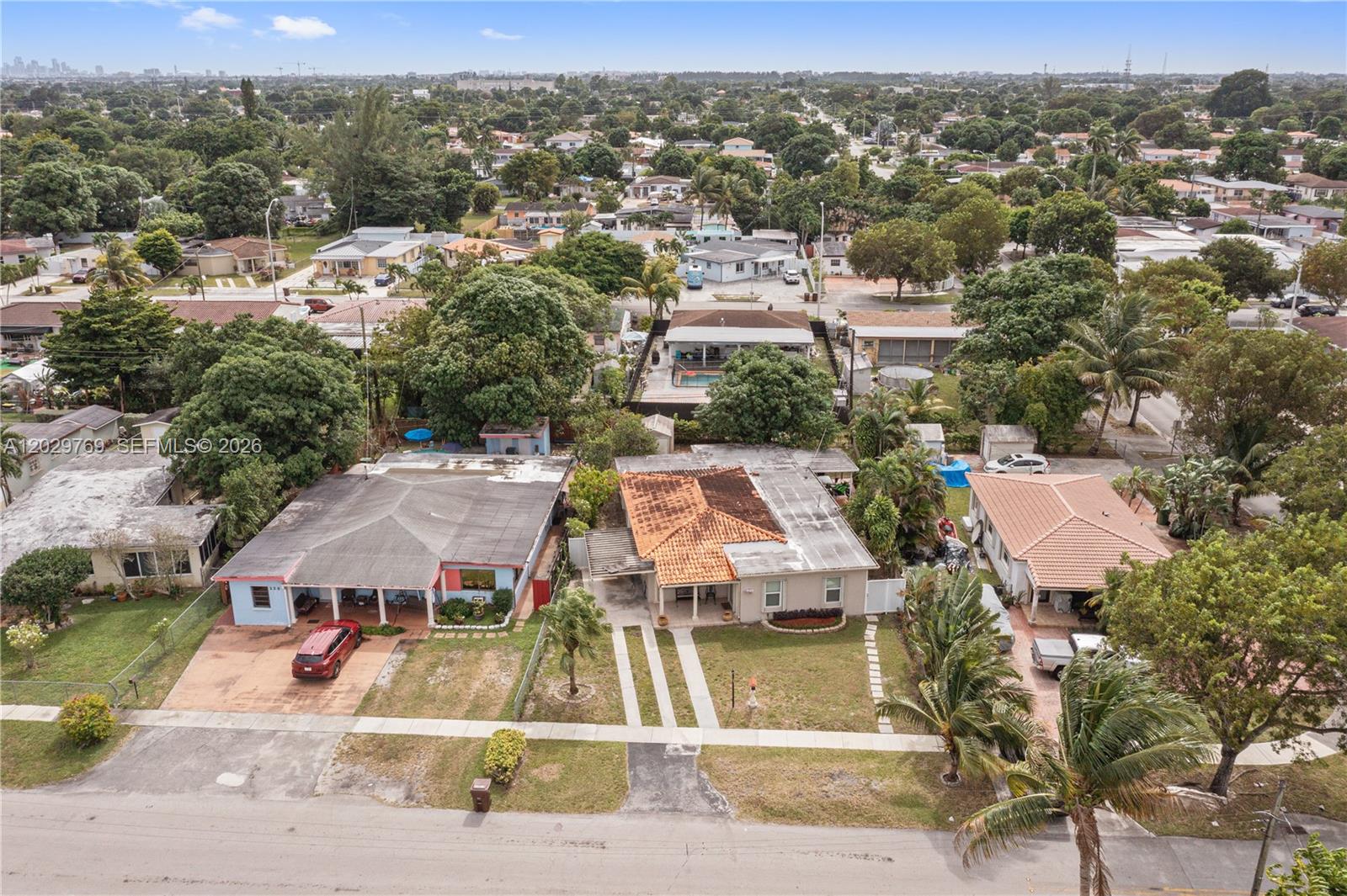 An aerial view shows three single-story houses with driveways and trees in a residential neighborhood — 210 E 61st St, Hialeah FL 33013, HIALEAH, FL