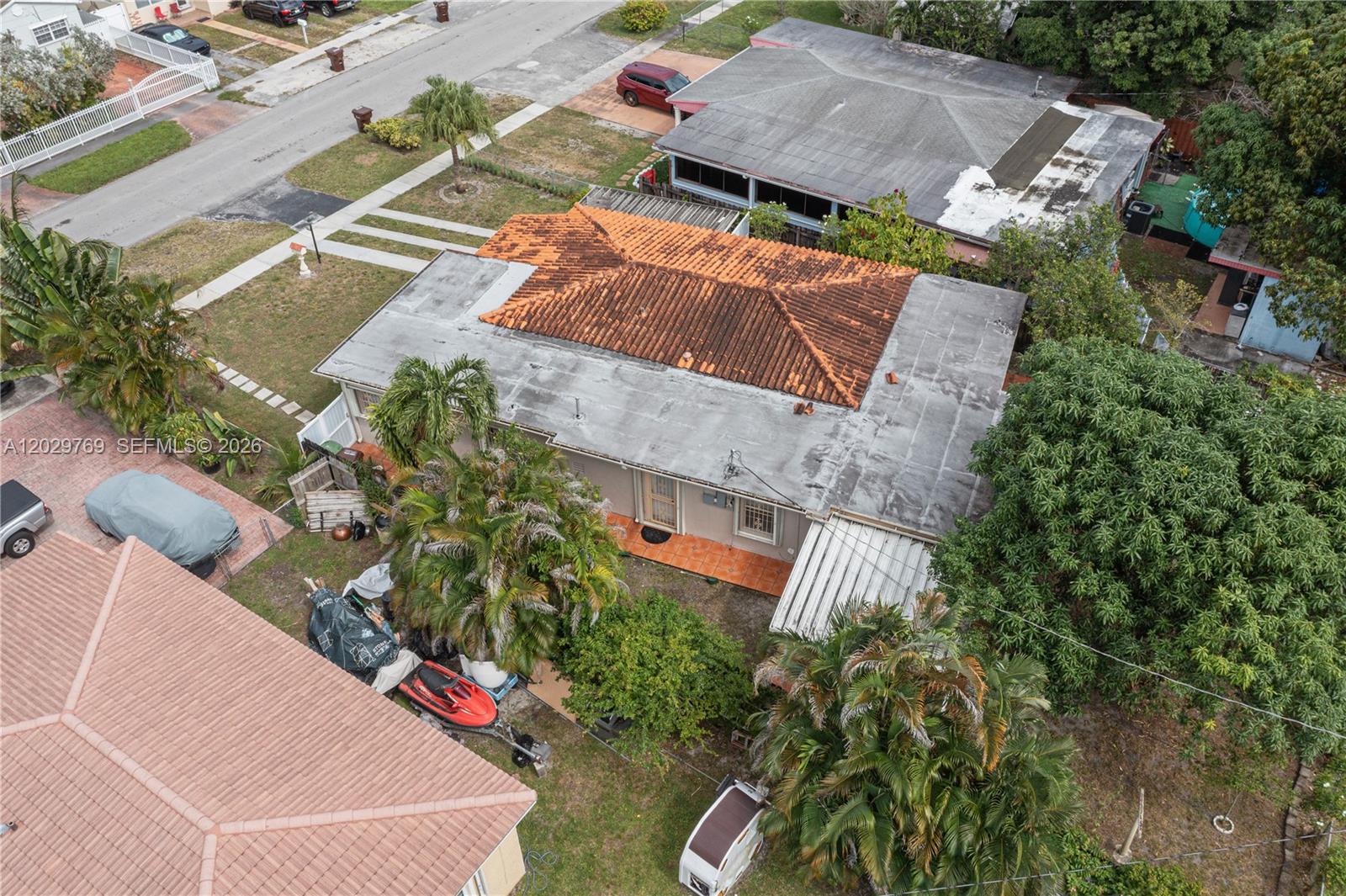 An aerial view shows a house with a central tiled roof and flat roof sections — 210 E 61st St, Hialeah FL 33013, HIALEAH, FL