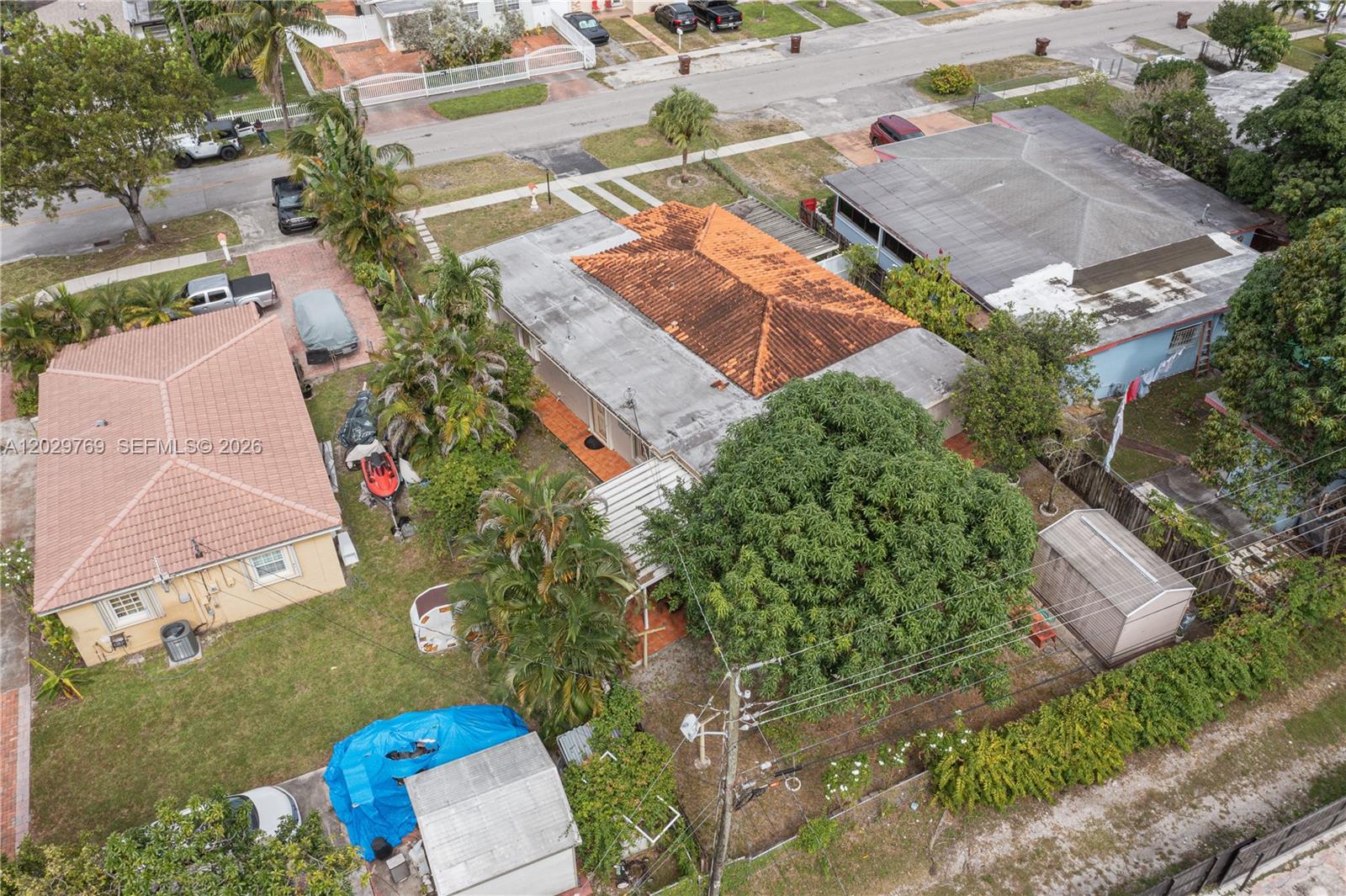An aerial view shows two houses with tiled roofs, a large tree, and a backyard shed — 210 E 61st St, Hialeah FL 33013, HIALEAH, FL