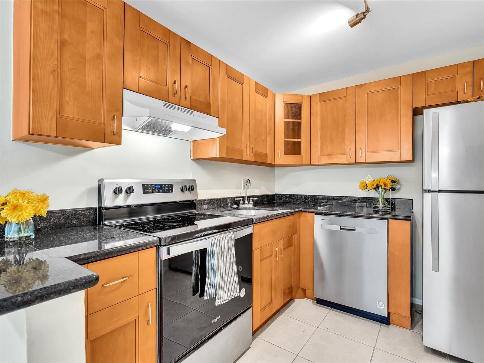 A kitchen features light wood cabinets, black granite countertops, and stainless steel appliances — 470 NW 20th Street, Boca Raton FL 33431, BOCA RATON, FL