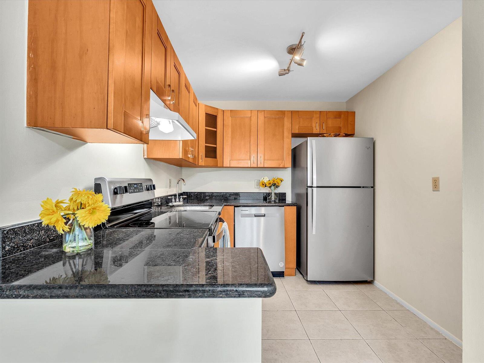 A kitchen with wood cabinets, black granite countertops, stainless steel appliances, and light tile flooring — 470 NW 20th Street, Boca Raton FL 33431, BOCA RATON, FL