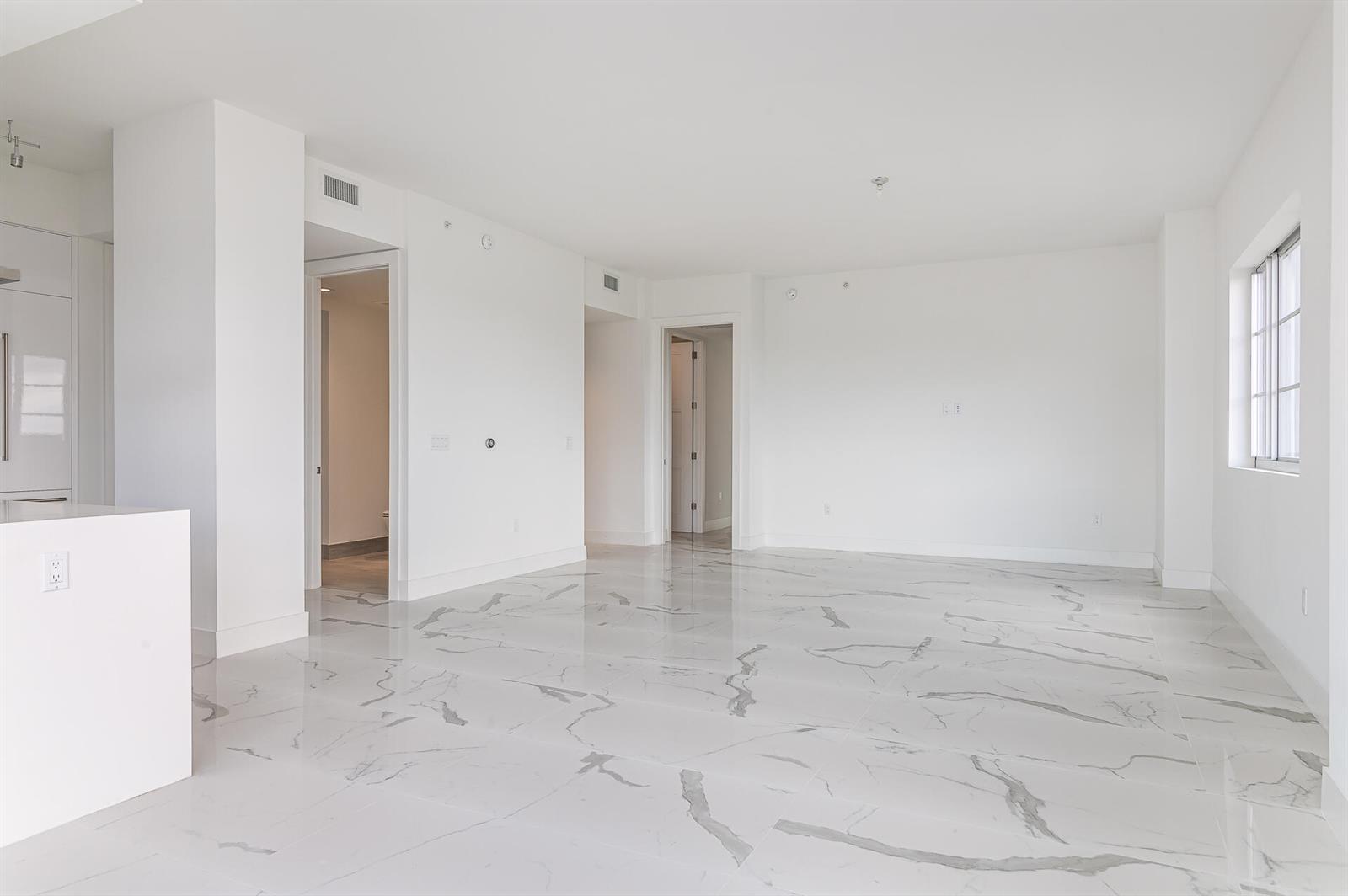 An empty living area with white walls and polished marble-look tile flooring — 155 E Boca Raton Road # 603, Boca Raton FL 33432, BOCA RATON, FL
