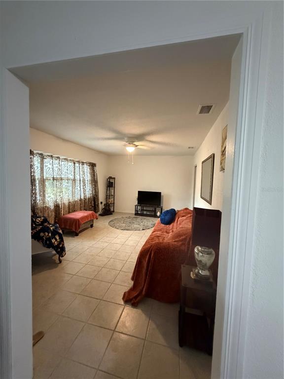 A living room features tile flooring, a large window with curtains, and a sofa — 105 LAKE SEARS DRIVE, WINTER HAVEN, FL