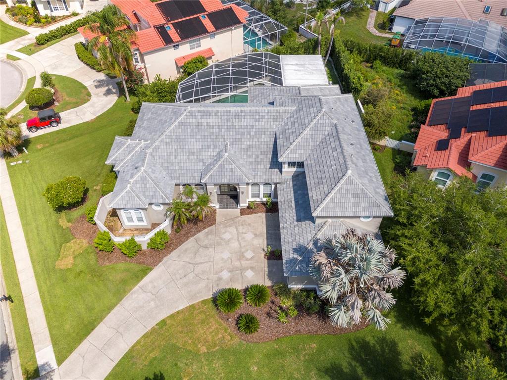 An aerial view shows a single-story house with a gray tile roof and pool enclosure — 8727 BECKINGHAM PLACE, ORLANDO, FL