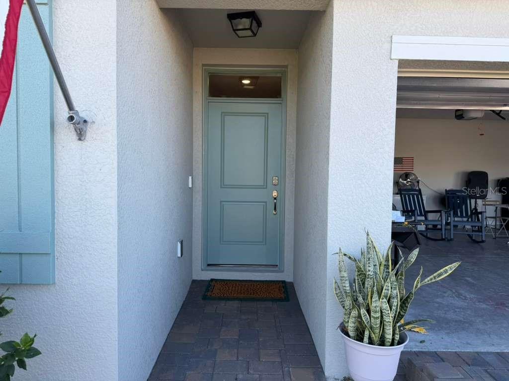 A light blue front door with a transom window sits under a covered entryway — 25275 ALCAZAR DRIVE, PUNTA GORDA, FL